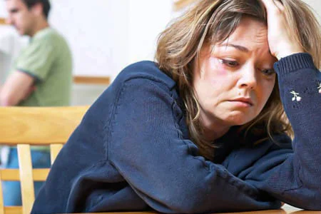 Женщина подавленно держит рукой голову